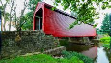 The bright red Roddy Road Covered Bridge spanning a creek near Thurmont, Maryland, USA