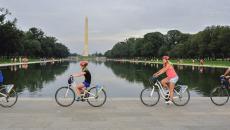People biking past the Washington Monument on a tour with Bike &amp; Roll in Washington, DC, USA