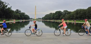People biking past the Washington Monument on a tour with Bike &amp; Roll in Washington, DC, USA