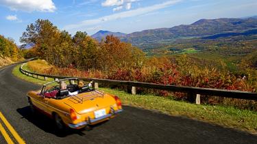 A convertible drives along the Blue Ridge Parkway in Virginia, USA.