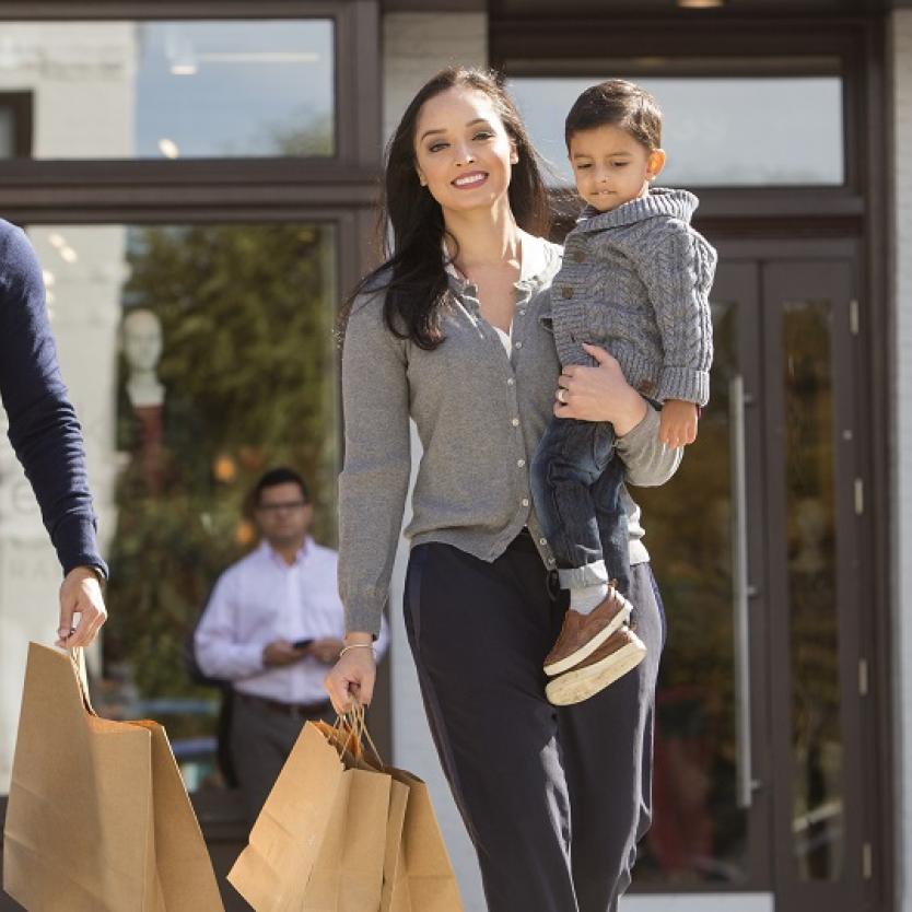 A family with small children walks with shopping bags in the Georgetown neighbourhood of Washington, DC.