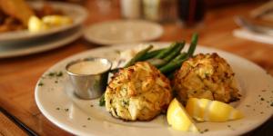 A dish of crab cakes with green beans