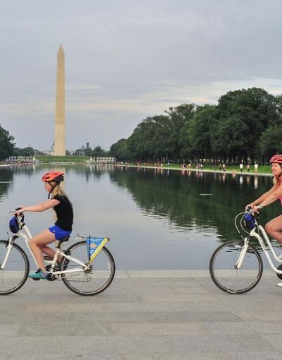 People biking past the Washington Monument on a tour with Bike &amp; Roll in Washington, DC, USA